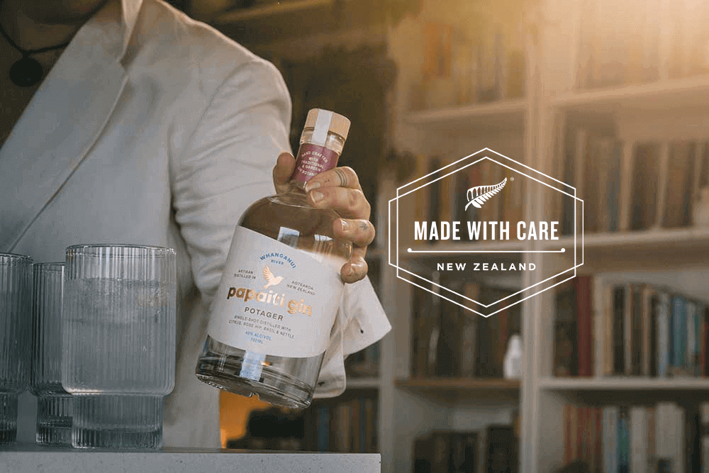 Person in white jacket holding a bottle of Papaiti Gin Potager next to a Made with Care logo